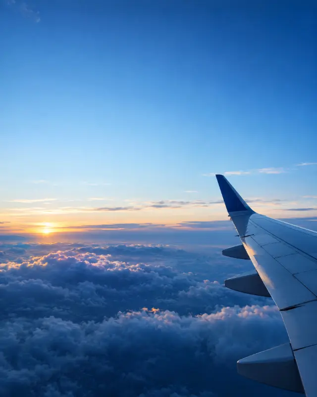 Asa de avião sobre as nuvens ao amanhecer